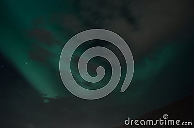 Beautiful aurora borealis on the night sky behind cloud cover Stock Photo