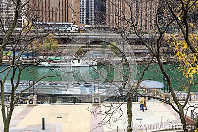 A beautiful autumn landscape along the Chicago River with yellow autumn trees, boats on the water and skyscrapers and hotels Editorial Stock Photo