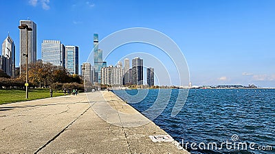 A beautiful autumn landscape at Lakefront Park with the rippling blue waters of Lake Michigan, autumn trees, people walking Editorial Stock Photo