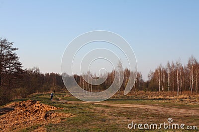 Beautiful autumn landscape with autumn nature. Sandy cliff, yellow trees, road with a walking girl, path to the forest. The Stock Photo