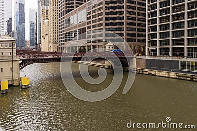 a beautiful autumn landscape with people walking and cars driving over the Monroe Street bridge over the Chicago River Editorial Stock Photo