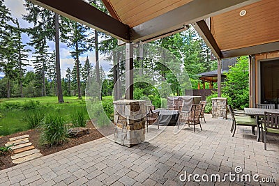 Beautiful back yard stone and brick patio with BBQ grill and luxury futniture Stock Photo