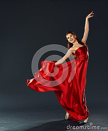 Beautiful ballerina dancing a long red dress flying Stock Photo