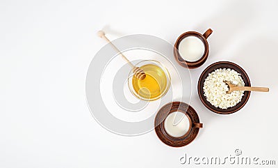 A healthy delicious breakfast of cottage cheese, milk and honey in handmade earthenware on a white background. Banner Stock Photo