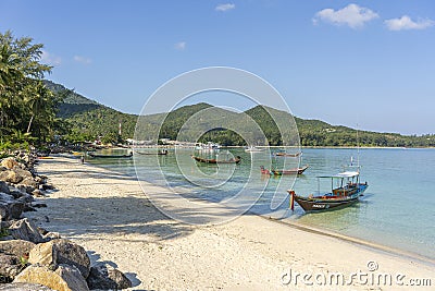 Beautiful bay with palm trees and boats. Tropical beach and sea water on the island Koh Phangan, Thailand Editorial Stock Photo