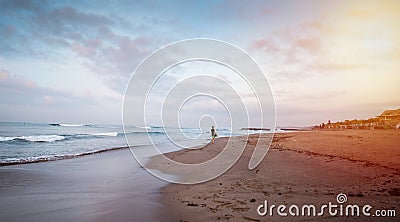 Beautiful beach with a surfer going to the waves early by the morning. Stock Photo