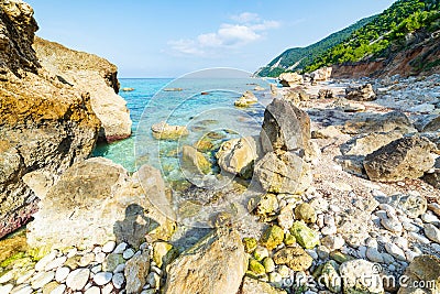 Beautiful beach and water bay in the greek spectacular coast line. Turquoise blue transparent water, unique boulders, Greece Stock Photo