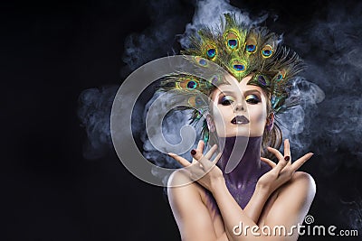 Beautiful big breast girl wearing peacock feathers in her hair a Stock Photo