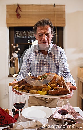 Family celebrating Christmas. Father bringing food. Stock Photo