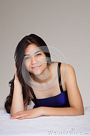 Beautiful biracial teen girl lying down, relaxing Stock Photo