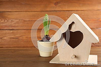 Beautiful bird house and potted hyacinth flower on wooden table, space for text Stock Photo