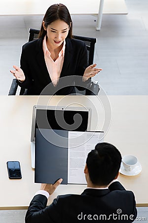 Beautiful black long hair Asian woman sitting and talking with businessman Stock Photo