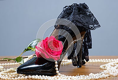 Black patent leather women`s shoes, pearls, rose and gloves Stock Photo