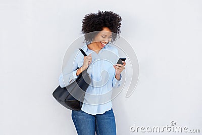 Beautiful black woman with purse looking at cellphone and laughing Stock Photo