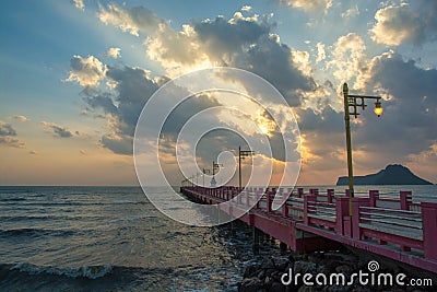 Beautiful blazing sunrises landscape with cloud and sun rays at Ao Prachuap bay with Saranwithi bridge stretching in to the sea Stock Photo