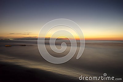 Beautiful blazing sunset landscape at Caspian sea and orange sky above it with awesome sun golden reflection on calm waves as a ba Stock Photo