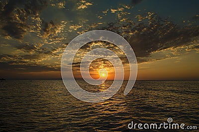 Beautiful blazing sunset landscape at Caspian sea and orange sky above it with awesome sun golden reflection on calm waves as a ba Stock Photo