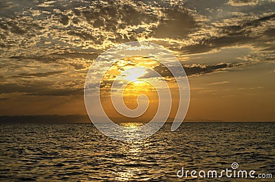 Beautiful blazing sunset landscape at Caspian sea and orange sky above it with awesome sun golden reflection on calm waves as a ba Stock Photo