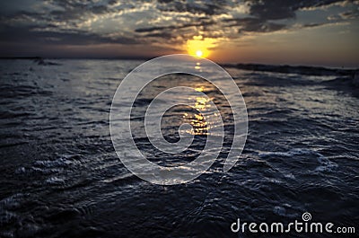 Beautiful blazing sunset landscape at Caspian sea and orange sky above it with awesome sun golden reflection on calm waves as a ba Stock Photo