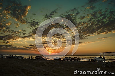 Beautiful blazing sunset landscape at Caspian sea and orange sky above it with awesome sun golden reflection on calm waves as a ba Stock Photo