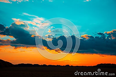 Beautiful blazing sunset landscape at over the meadow and orange sky above it. Stock Photo