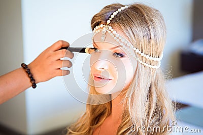 Beautiful blond bride doing makeup in her wedding day near mirror. Bride makeup. Stock Photo