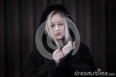 Beautiful blond lady wear hooded black jacket Stock Photo