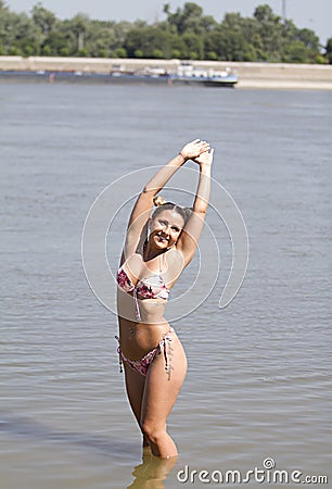 Beautiful blonde.On the beach.In water.She poses.She has a modern hairstyle. Stock Photo