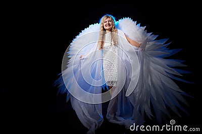 A beautiful blonde girl with curly hair and white wings looks like an nice angel Stock Photo