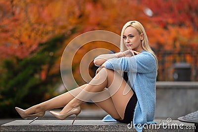 Girl with perfect legs posing in the autumn park. Stock Photo