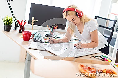A young girl in the headphones stands near the table and holds a marker in her hand. On the table is a magnetic board. Stock Photo