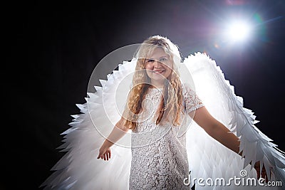 A beautiful blonde woman with curly hair and white wings looks like an nice angel Stock Photo