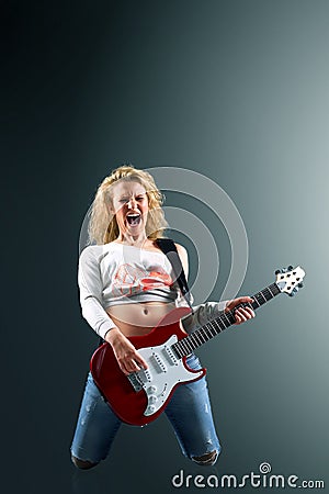 Beautiful blonde woman with a guitar sings a rock song Stock Photo