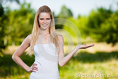 Beautiful blonde woman in park holding anything Stock Photo