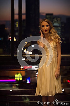 Beautiful blonde woman on urban balcony Stock Photo