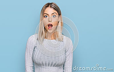 Beautiful blonde woman wearing casual clothes afraid and shocked with surprise and amazed expression, fear and excited face Stock Photo