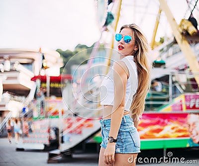 Beautiful blonde woman wearing sunglasses close-up portrait of a young girl hipster in the park attraction.Stylish happy youn Stock Photo