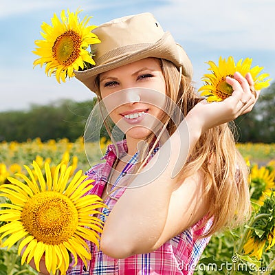 Beautiful Blondy Woman in Cowboy Hat with Sunflowers. Stock Photo