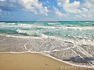 Beautiful blue aquamarine colour sea ocean water landscape with white foam. Seascape nature with waves, blue sky and sandy beach Stock Photo