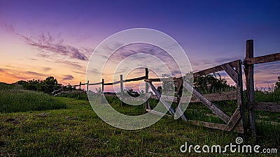 Beautiful blue-colored landscape, old wooden fence in the foreground Stock Photo