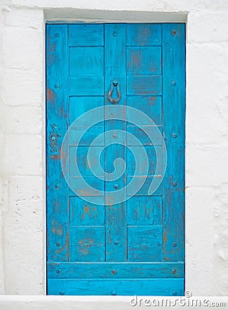 Old blue door on white stone wall Stock Photo