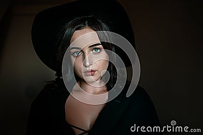 Beautiful blue-eyed young girl in a black hat and a black jacket Stock Photo