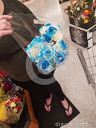 Beautiful blue flowers and a womans feet in sandals Stock Photo