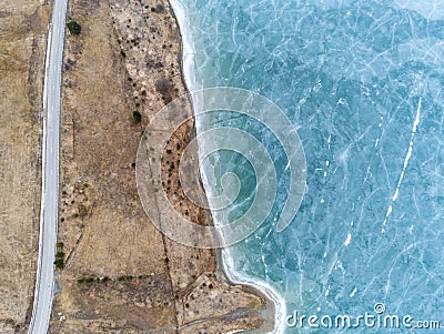 Beautiful blue frozen crystal clean lake near asphalt road aerial drone view Stock Photo