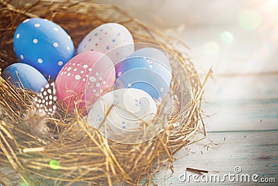 Rustic Colorful Eggs in the Hay Nest on the Wooden Background Stock Photo