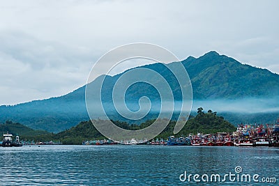 beautiful blue sea, fisherman village on coast and have big mountain, fog are bacgkround. this image for landscape,seascape and n Editorial Stock Photo