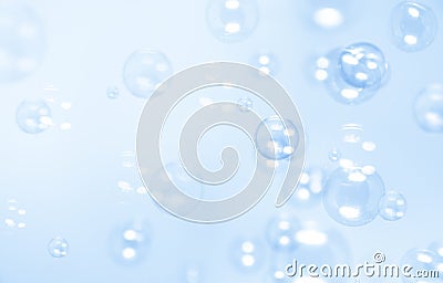 Beautiful blurry bokeh clear soap bubbles float on blue background Stock Photo