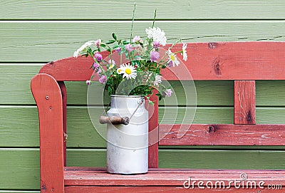 Bouquet of field flowers in vintage milk can Stock Photo