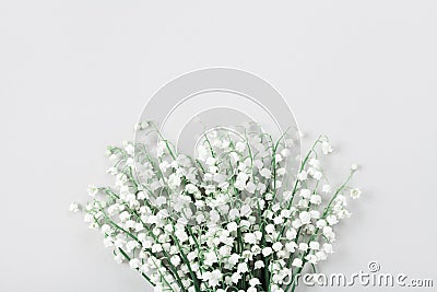 Beautiful bouquet of flowers lily of the valley on pastel table from above. Minimal composition and flat lay style. Stock Photo
