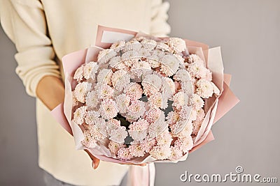 a beautiful mono bouquet of fresh flowers in the hands of a florist. A gift bouquet for any holiday. A very nice female Stock Photo